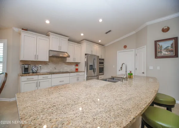 a kitchen with stainless steel appliances granite countertop a sink refrigerator and cabinets