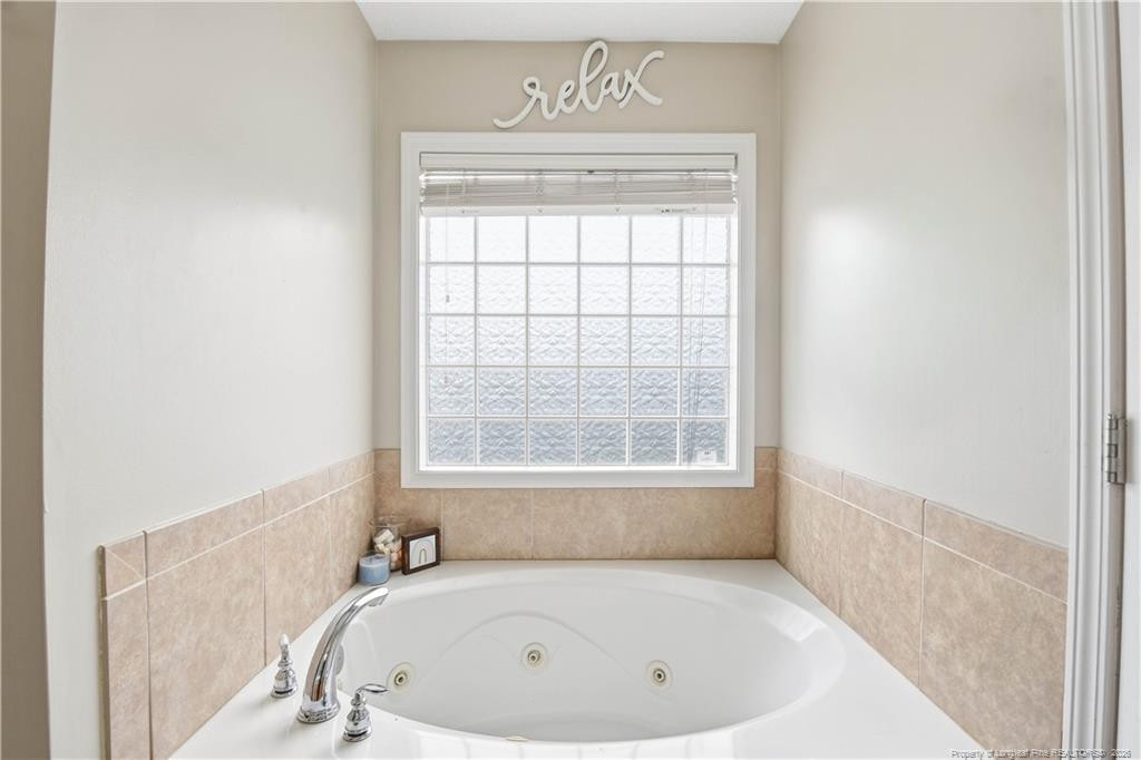 212 Lennox Loop Raeford, NC 28376 - Photo 32 of 47 a bathroom with a bathtub and a window