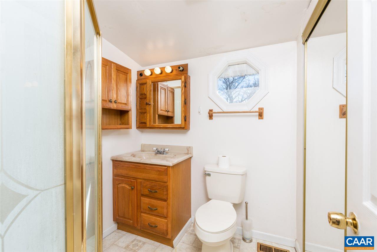 53 McKamy Springs Road Middlebrook, VA 24459 - Photo 16 of 46 a bathroom with a toilet a sink a window and a shower