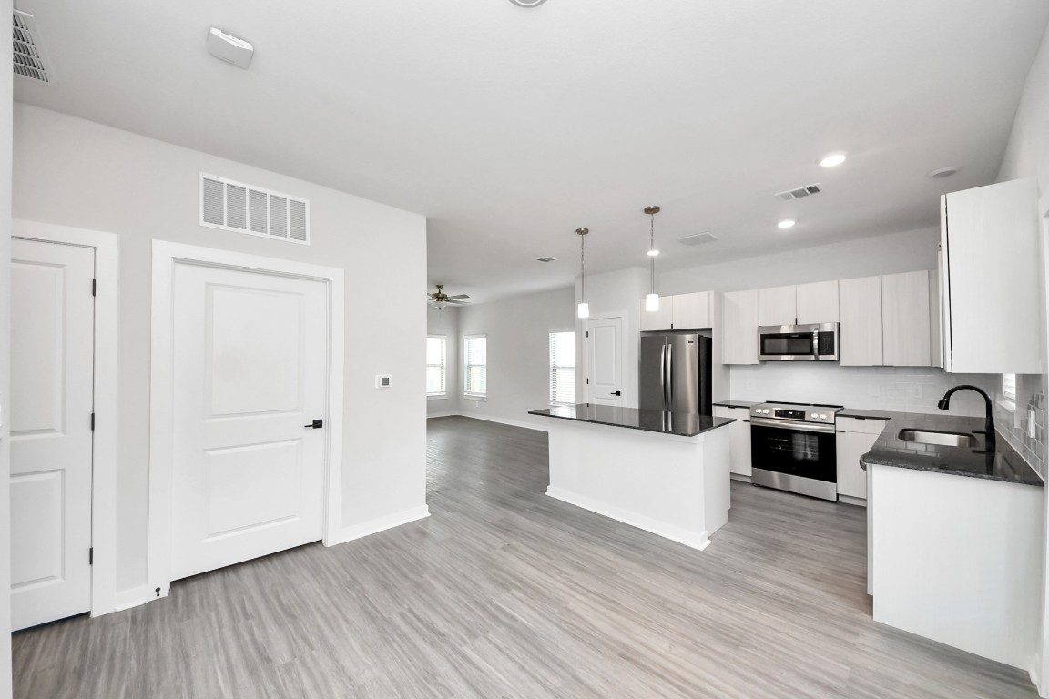 7711 Longmire Road, Unit 158 Conroe, TX 77304 - Photo 42 of 48 Boasting luxury finishes-stylish Island kitchen,granite counters,subway tile backsplash,ample custom cabinet space,stainless appliances,refrigerator,full size washer&dryer included,wood-like flooring throughout,open concept floor plan.