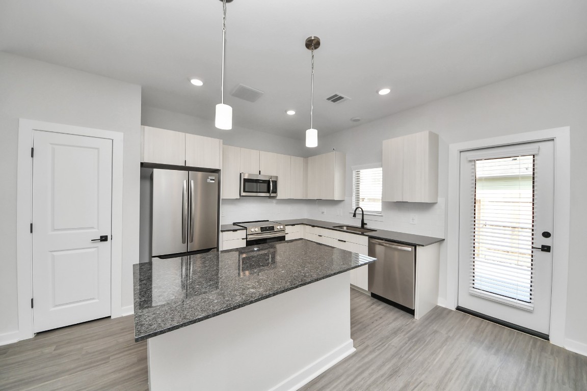 7711 Longmire Road, Unit 158 Conroe, TX 77304 - Photo 36 of 48 Boasting luxury finishes-stylish Island kitchen,granite counters,subway tile backsplash,ample custom cabinet space,stainless appliances,refrigerator,full size washer&dryer included,wood-like flooring throughout,open concept floor plan.