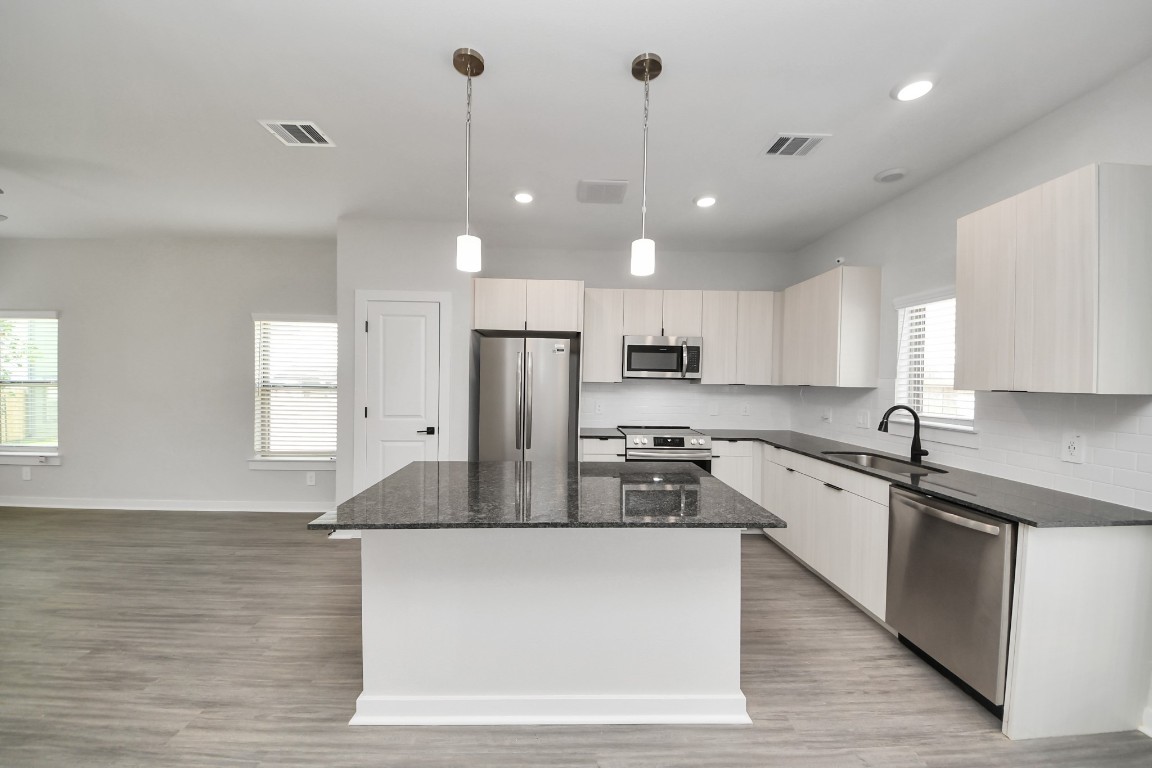 7711 Longmire Road, Unit 158 Conroe, TX 77304 - Photo 37 of 48 Boasting luxury finishes-stylish Island kitchen,granite counters,subway tile backsplash,ample custom cabinet space,stainless appliances,refrigerator,full size washer&dryer included,wood-like flooring throughout,open concept floor plan.