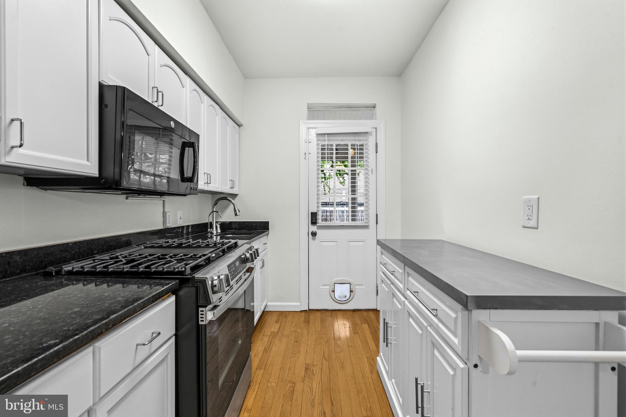 1504 Gales Street Northeast Washington, DC 20002 - Photo 8 of 24 a kitchen with granite countertop a stove and a microwave