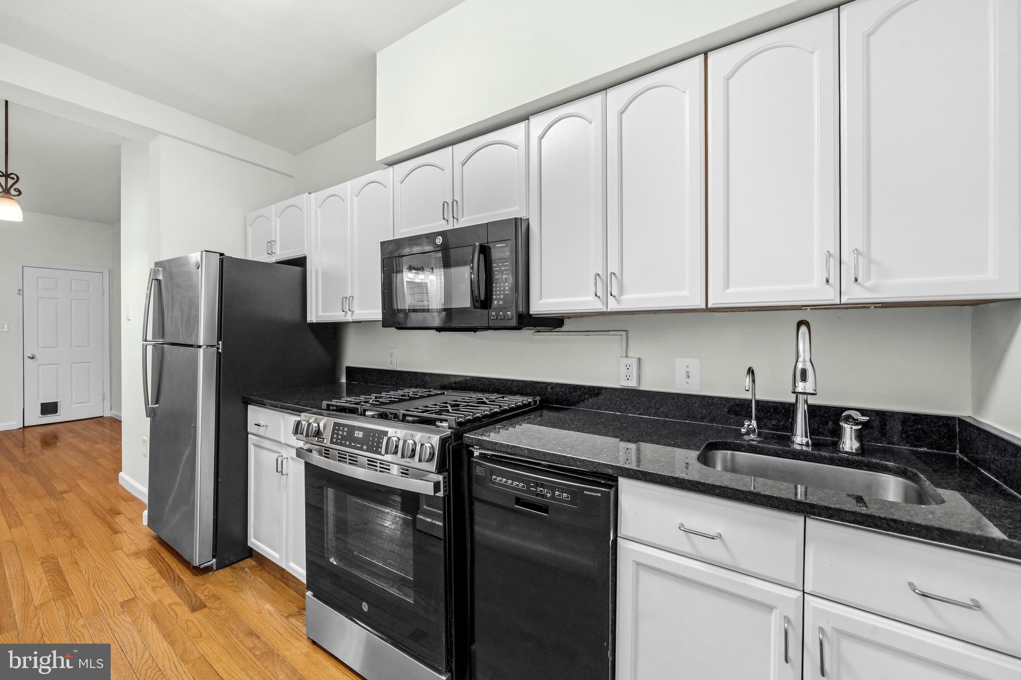 1504 Gales Street Northeast Washington, DC 20002 - Photo 9 of 24 a kitchen with granite countertop white cabinets and stainless steel appliances
