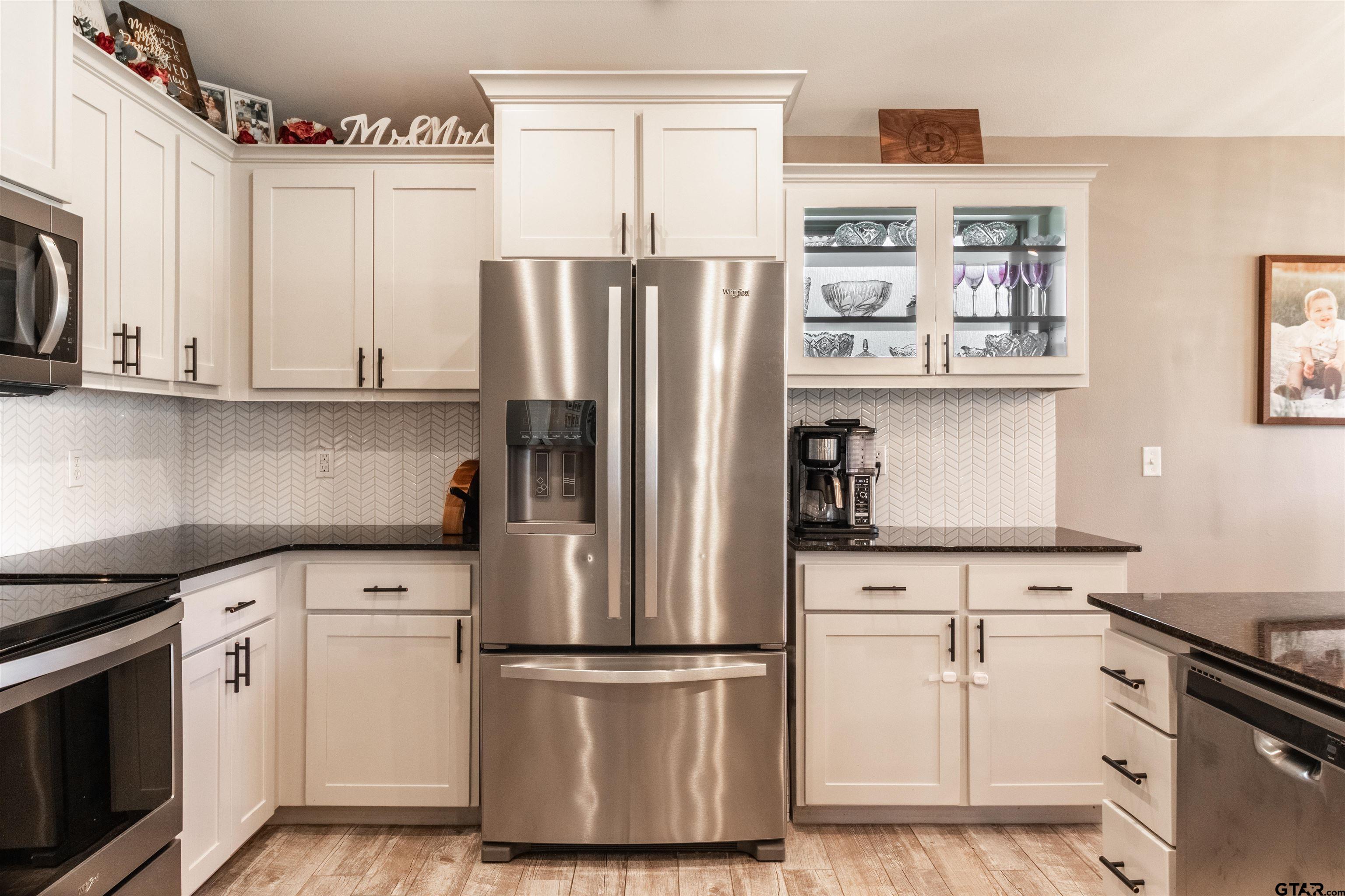 15326 Spring Oaks Drive Lindale, TX 75771 - Photo 12 of 29 a kitchen with stainless steel appliances white cabinets and a refrigerator
