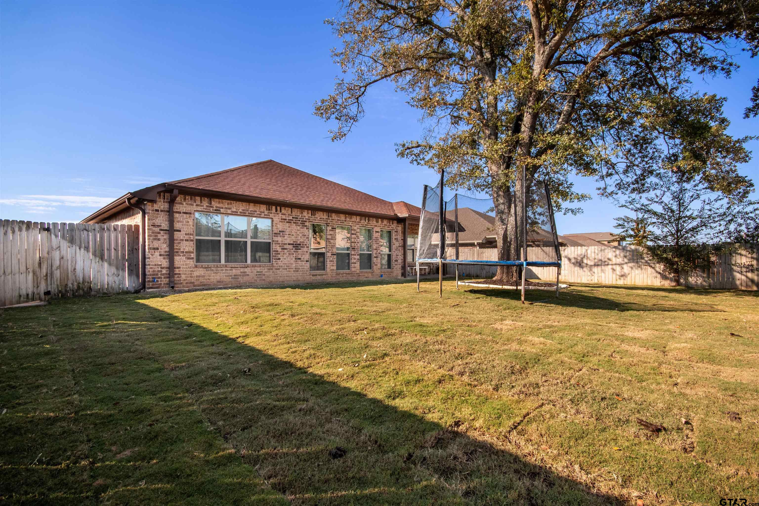 15326 Spring Oaks Drive Lindale, TX 75771 - Photo 27 of 29 a blue swimming pool is in front of a house