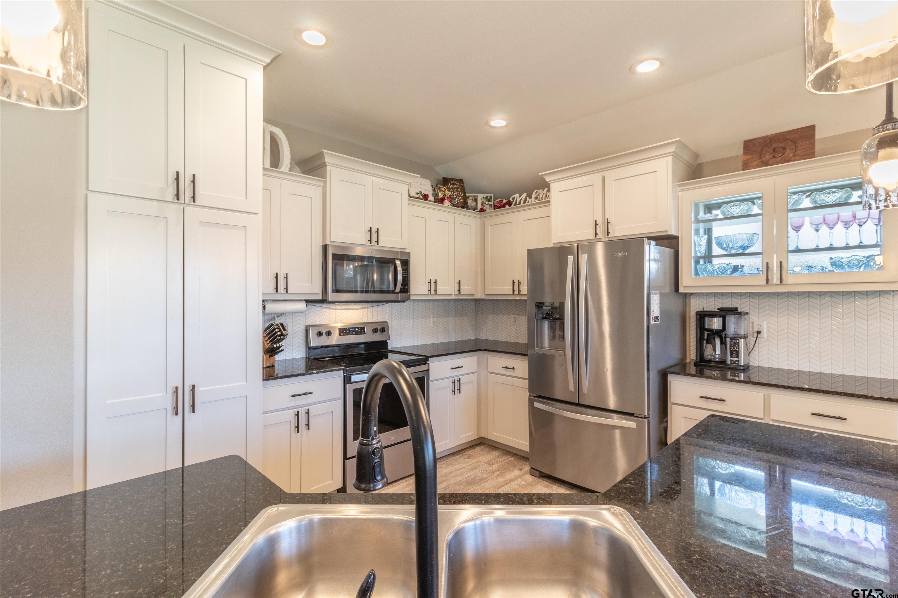 15326 Spring Oaks Drive Lindale, TX 75771 - Photo 10 of 29 a kitchen with stainless steel appliances a refrigerator a stove a sink and a counter