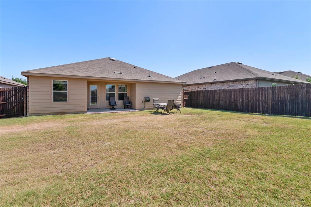 409 Wilson Way Denton, TX 76207 - Photo 28 of 33 Spacious backyard featuring a full privacy fence, a concrete patio, and a light-colored siding exterior