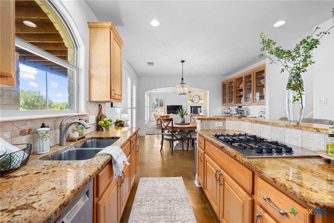 600 Lake Side Cove Georgetown, TX 78628 - Photo 17 of 48 a kitchen with stainless steel appliances granite countertop a stove a sink dishwasher a oven a dining table and chairs with wooden floor