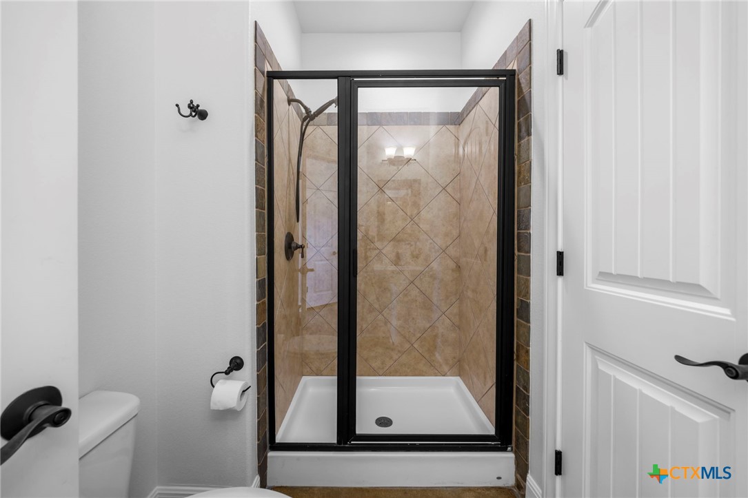 600 Lake Side Cove Georgetown, TX 78628 - Photo 26 of 48 a bathroom with a glass shower door