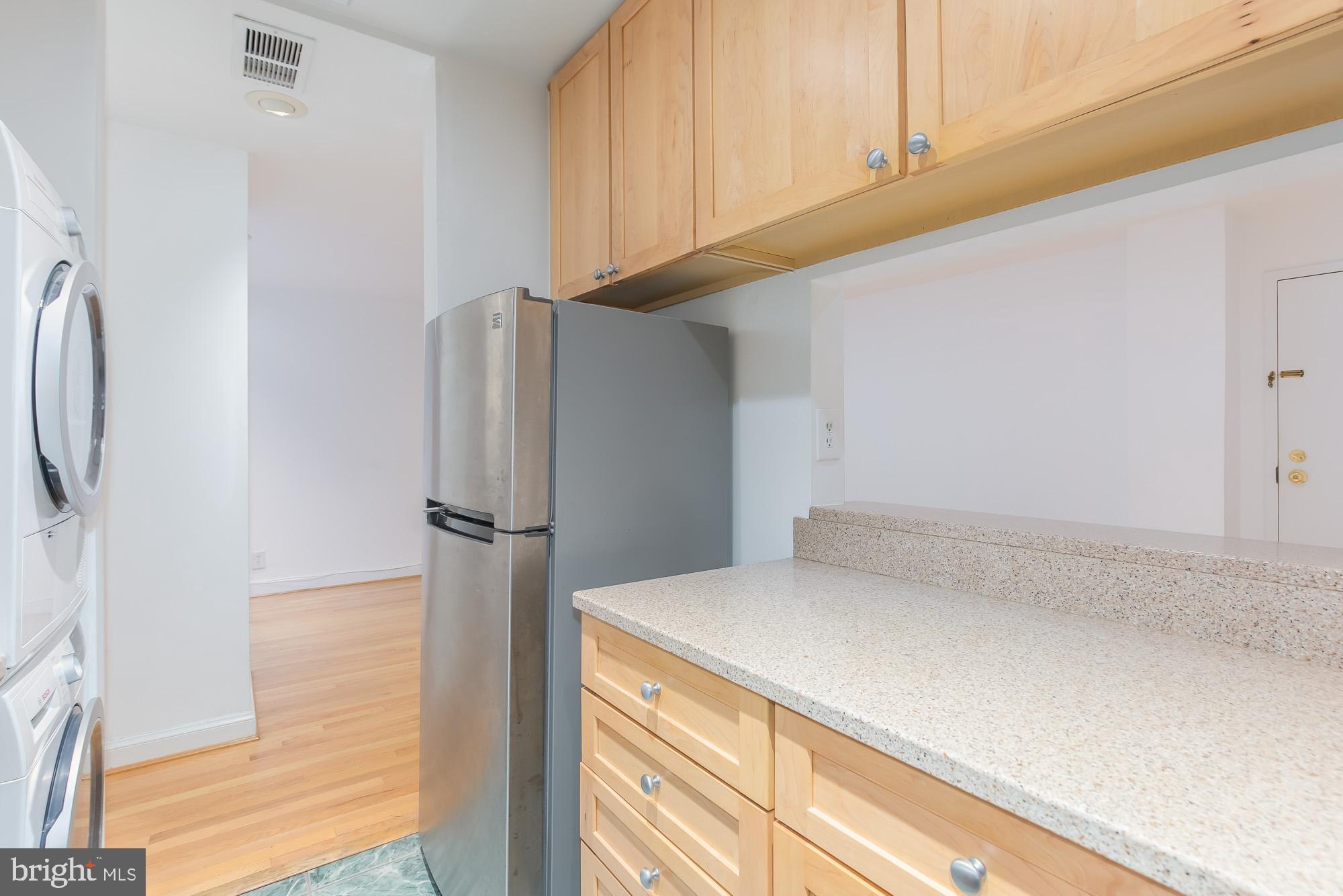 1316 New Hampshire Avenue Northwest, Unit 503 Washington, DC 20036 - Photo 15 of 24 a kitchen with a refrigerator and cabinets