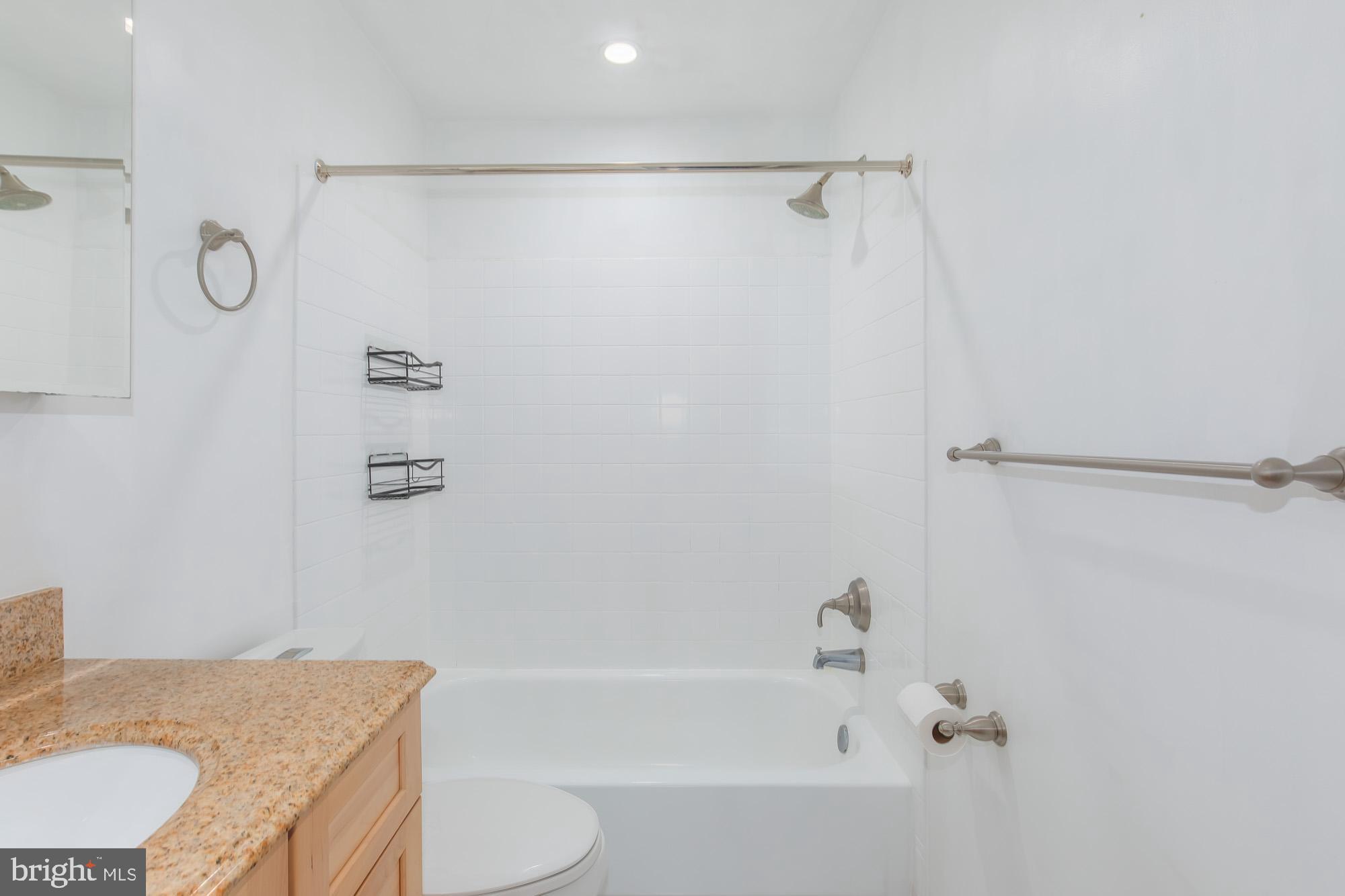 1316 New Hampshire Avenue Northwest, Unit 503 Washington, DC 20036 - Photo 21 of 24 a bathroom with a granite countertop bathtub shower sink vanity and toilet