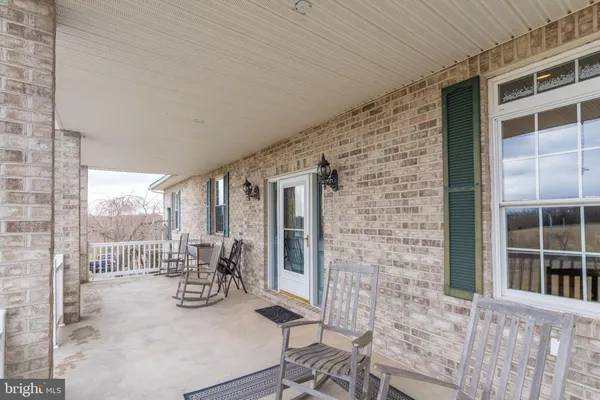 a spacious bedroom with a bed a couch and a chandelier