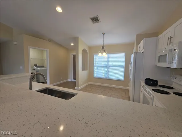 a kitchen with stainless steel appliances kitchen island granite countertop a refrigerator and a sink