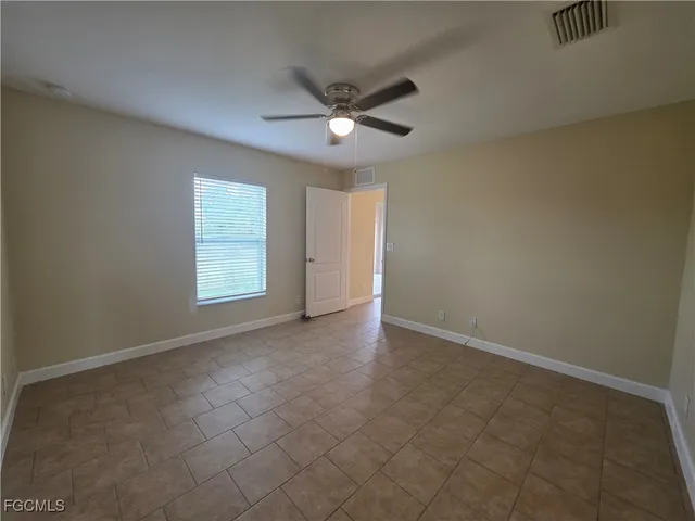an empty room with closet and a ceiling fan