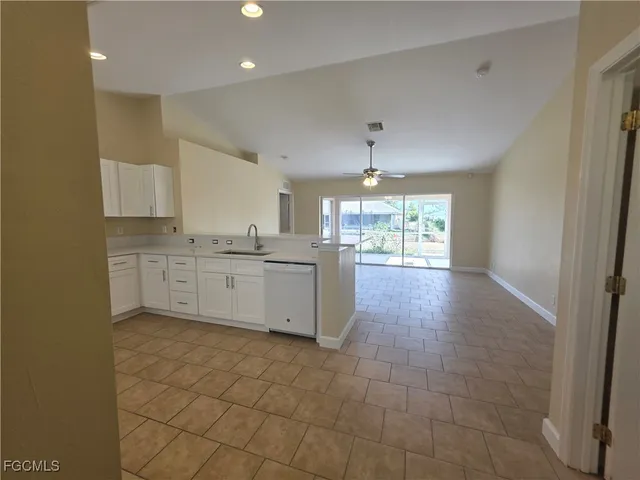 a large kitchen with stainless steel appliances a counter space a sink a window and cabinets