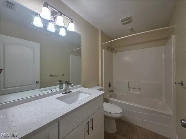 a bathroom with a granite countertop sink a toilet and shower