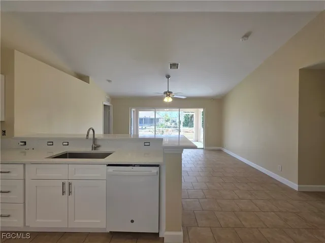 a view of a kitchen with granite countertop white cabinets and a chandelier