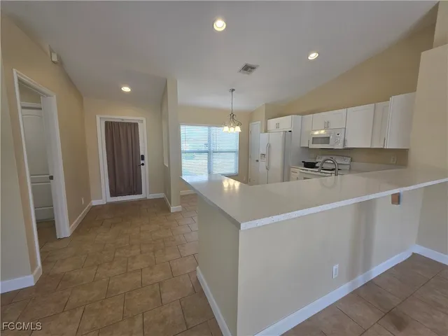 a kitchen with kitchen island a sink stainless steel appliances and white cabinets