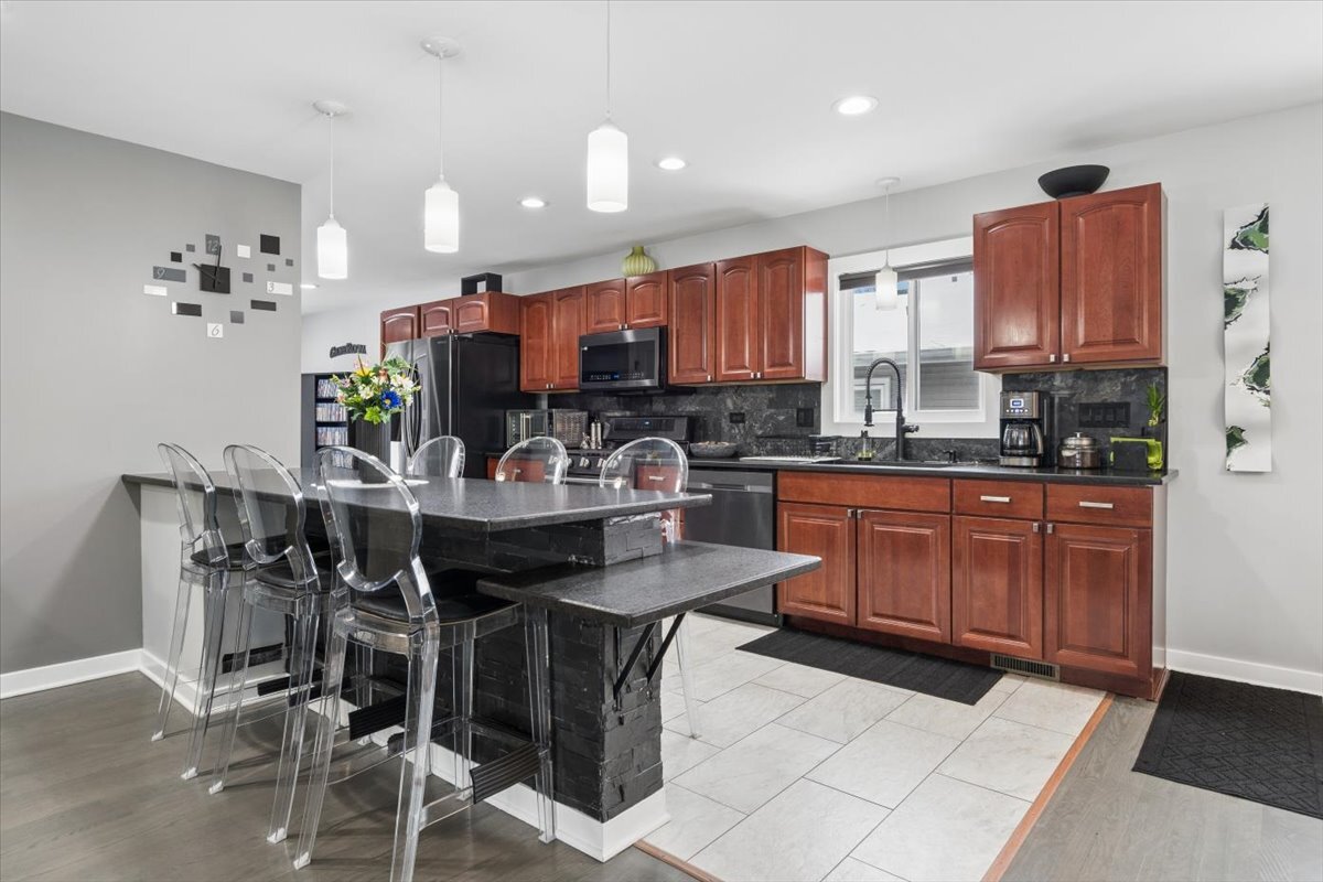 1109 Edson Avenue Lombard, IL 60148 - Photo 5 of 20 a kitchen with kitchen island granite countertop a sink cabinets and window