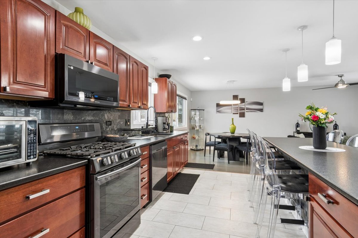 1109 Edson Avenue Lombard, IL 60148 - Photo 7 of 20 a kitchen with stainless steel appliances granite countertop a stove a sink and a microwave