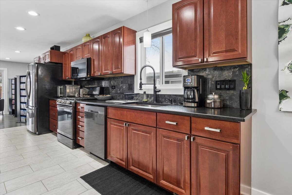 1109 Edson Avenue Lombard, IL 60148 - Photo 8 of 20 a kitchen with stainless steel appliances granite countertop a sink stove and cabinets