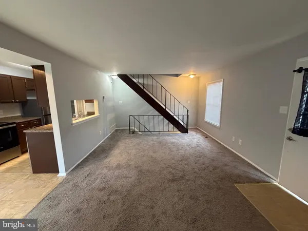 a view of a livingroom with wooden floor and stairs