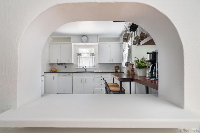 a living room with stainless steel appliances kitchen island granite countertop furniture and a potted plant