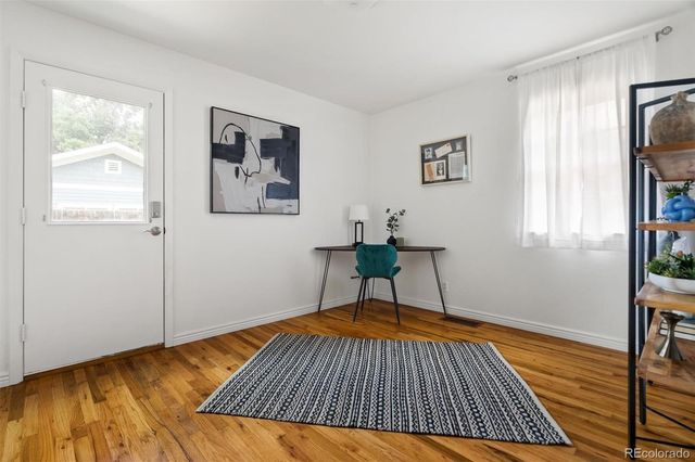 a view of a bedroom with wooden floor and window
