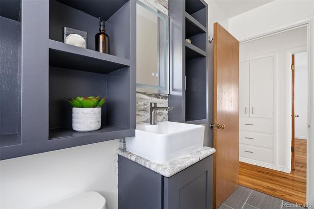 a bathroom with a granite countertop sink and a mirror
