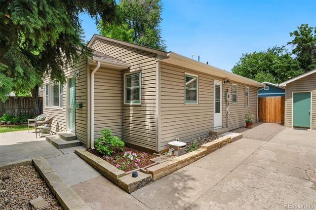 a front view of house with yard and trees in the background