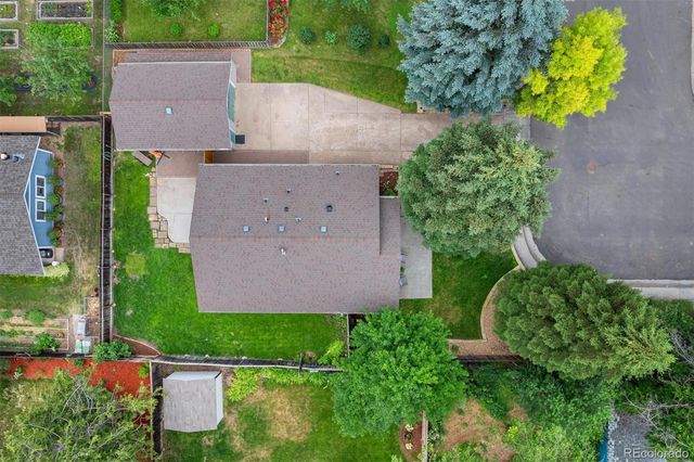 an aerial view of a house with a yard and a large tree