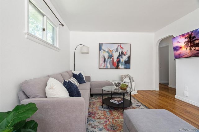 a living room with furniture and wooden floor