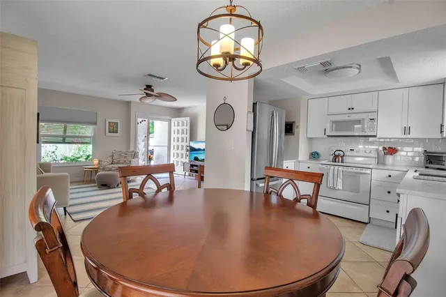 a living room with dining table and a clock