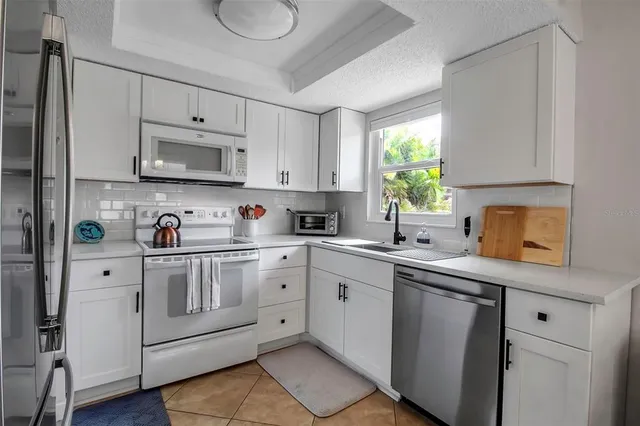 a kitchen with stainless steel appliances white cabinets a sink and a stove