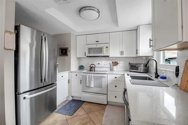 a kitchen with stainless steel appliances granite countertop a refrigerator sink and stove