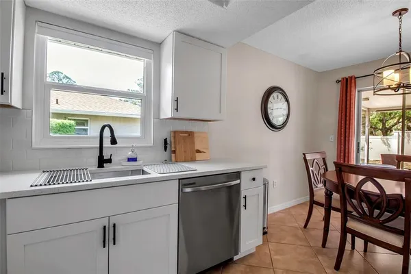 a kitchen with a sink a window and cabinets