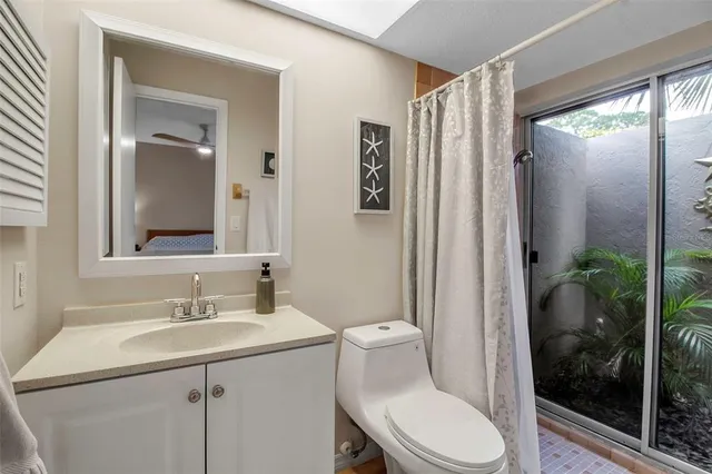 a bathroom with a sink a mirror a toilet and shower