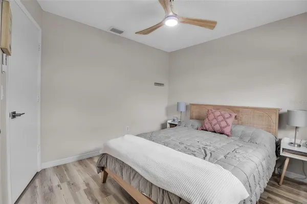 a bedroom with a large bed and a chandelier fan