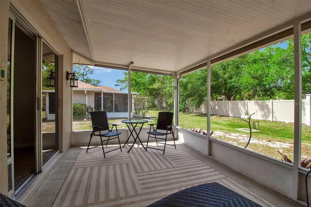 a view of a two chairs in the balcony next to a yard