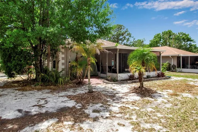 a view of a house with backyard sitting area and garden