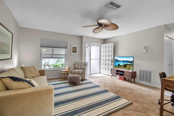 a living room with furniture kitchen view and a window