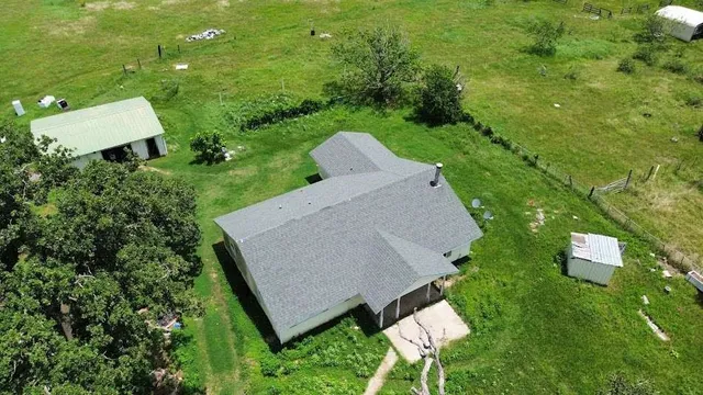 an aerial view of a house with swimming pool and garden