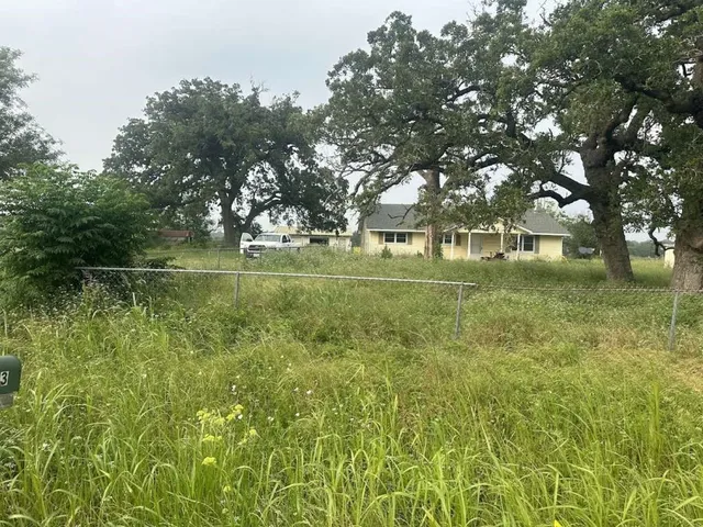 a backyard of a house with lots of green space and fountain