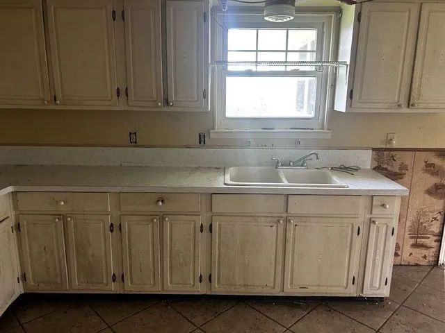 a kitchen with stainless steel appliances granite countertop white cabinets sink and window