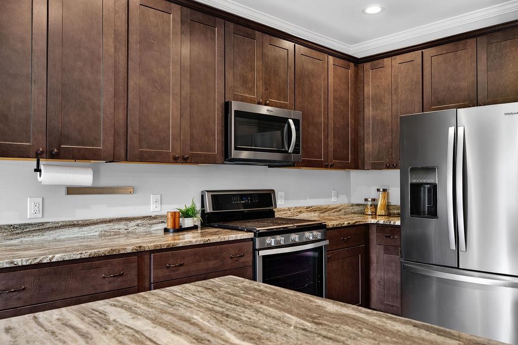 190 Montgomery Road Staunton, VA 24401 - Photo 13 of 46 a kitchen with granite countertop wooden cabinets a stove top oven and refrigerator