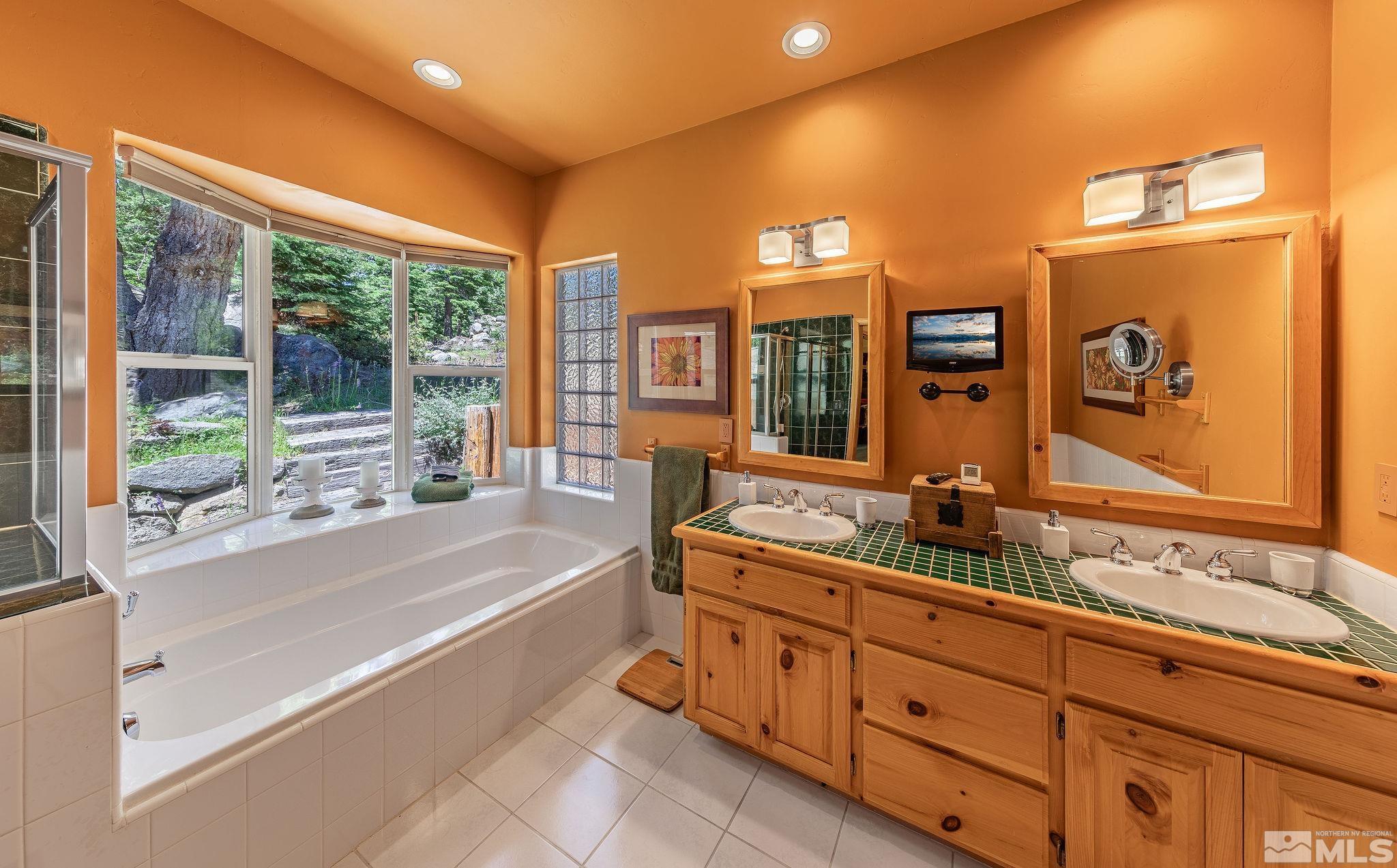 228 Sunflower Circle Stateline, NV 89449 - Photo 15 of 40 a bathroom with a tub sink and mirror