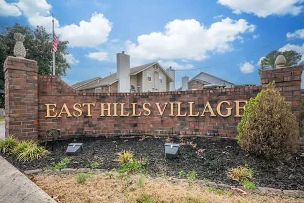 a view of a sign board with large trees