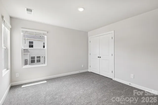 an empty room with windows and closet