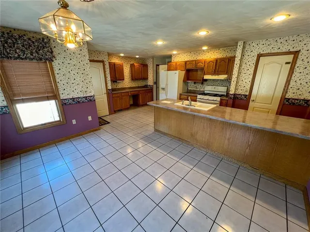a large kitchen with stainless steel appliances granite countertop a sink and cabinets